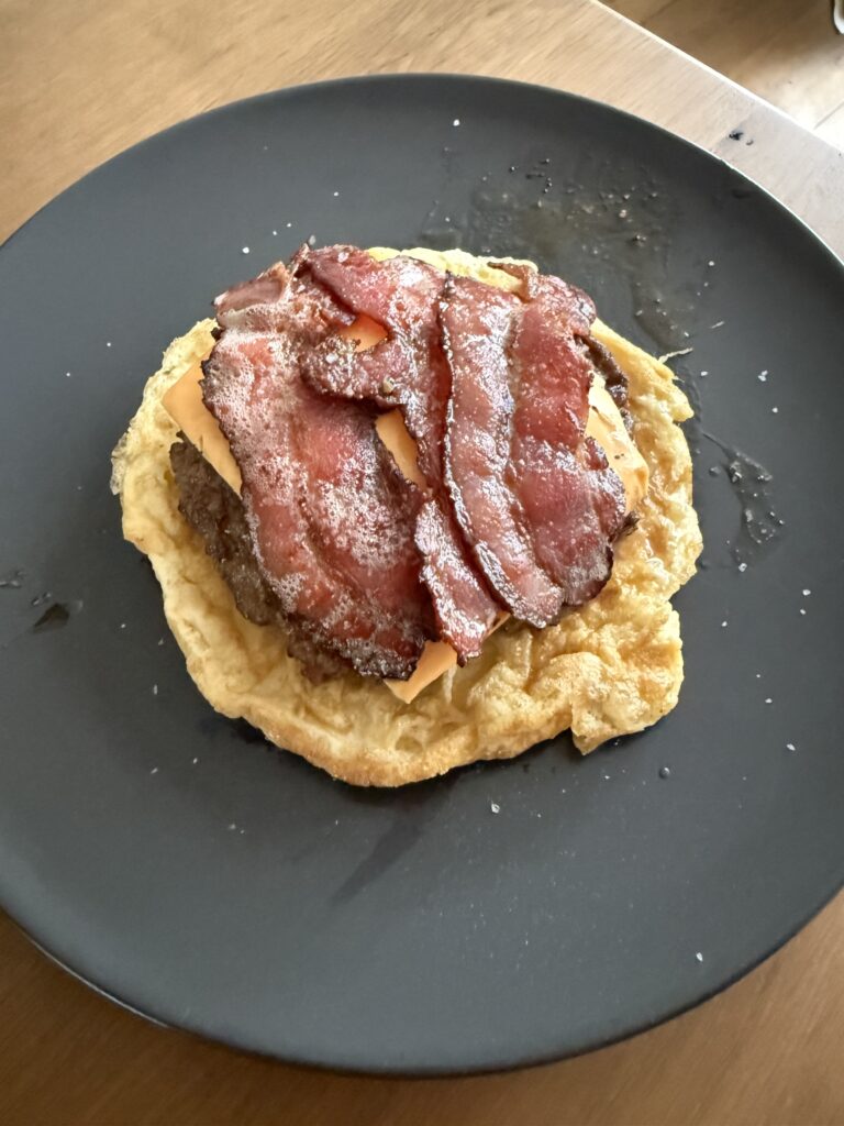Egg Bun-variant: runderburger en bacon geserveerd op een luchtig omeletje in plaats van brood.